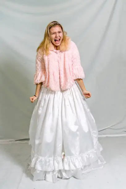 Screaming blonde fourteen year old in ballroom gown and jacket