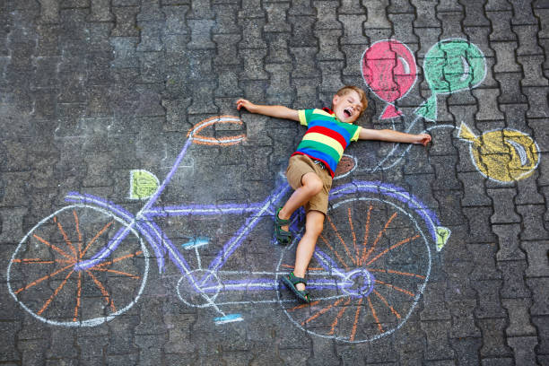 istock little kid boy having fun with bike chalks picture 1014150480