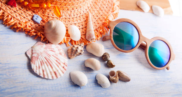 istock beach accessories glasses hat cockleshells on wood deck. 1014151876