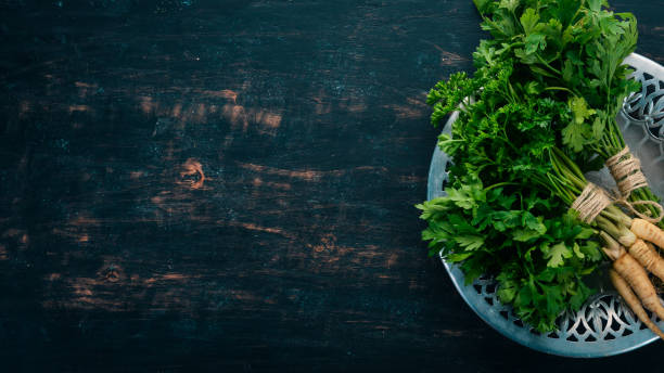 istock Fresh green parsley. Root parsley. On a wooden background. Top view. Copy space. 1014159444