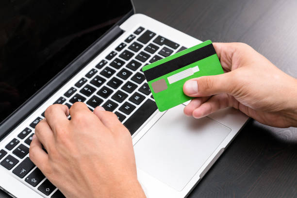 Young business man typing in credit card info on a computer keyboard. Credit card visible in hand. Close up, business office workplace. Debt, paying bills, debit card info, online banking, mortgage hombre de negocios joven escribiendo información de tarjeta de crédito en un teclado de computadora. de crédito tarjeta visible en la mano. cierre para arriba, trabajo de oficina de negocios. deuda, pagar facturas, información de tarjeta de débito, ba