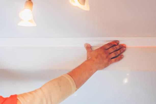 istock finishing works - the worker decorates the ceiling with stucco molding 1014163196