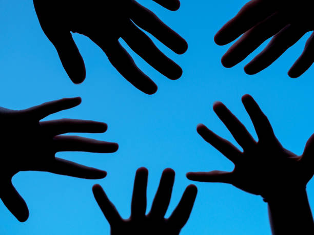 istock Dark hands in front of a blue sky 1014163616
