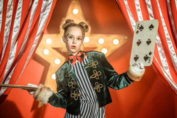istock Young Girl Illusionist Shows Card Trick 1014165024