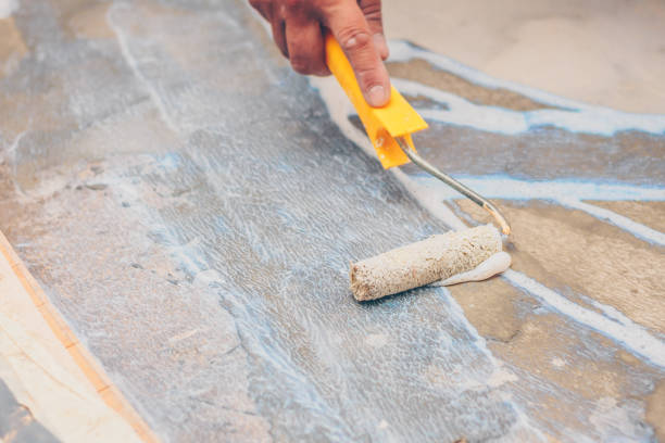 istock finishing works - a working roller primer floors for laying tiles 1014165026