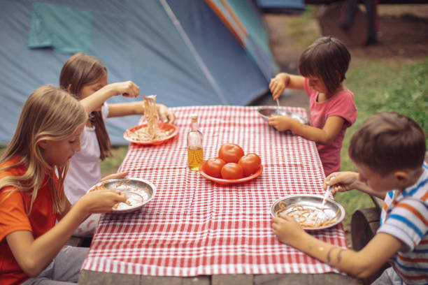 istock Children on camping eating spaghetti 1014178850