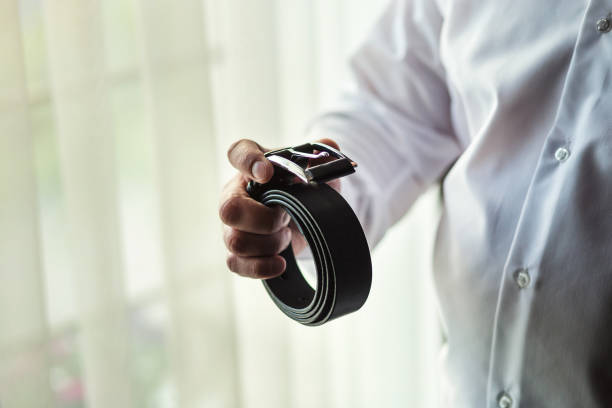 uomo d'affari che indossa un concetto di cintura, moda e abbigliamento, sposo che si prepara la mattina prima della cerimonia - cuff link suit men wedding foto e immagini stock