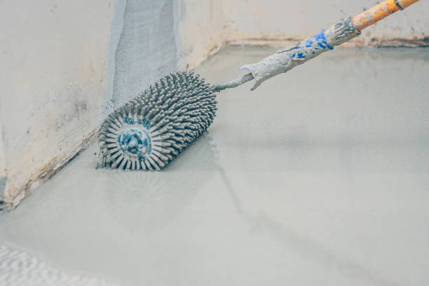 istock finishing work - the worker makes the floor floor with a needle roller 1014185500