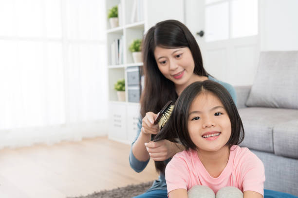 istock smiling pretty mother using brush combing hair 1014185902