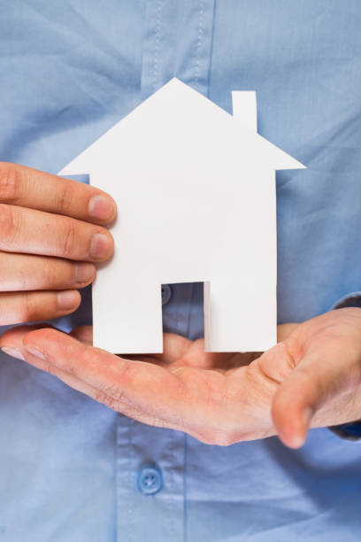 istock Man holding paper house in his hands 1014186724