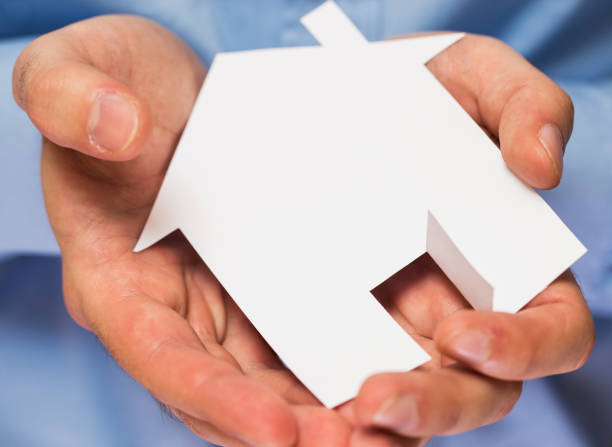 istock Man holding paper house in his hands 1014186834