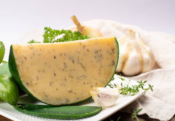 fromage à pâte dure spécialité néerlandaise fait de lait de vaches avec différentes épices et herbes vertes fraîches - basiron photos et images de collection