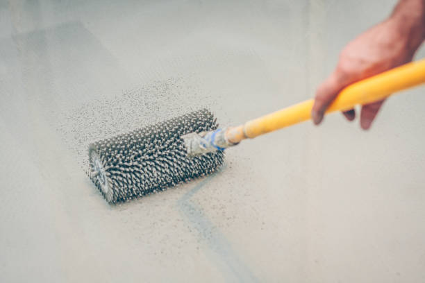 istock finishing work - the worker makes the floor floor with a needle roller 1014194202