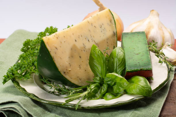 fromage à pâte dure spécialité néerlandaise fait de lait de vaches avec différentes épices et herbes vertes fraîches - basiron photos et images de collection