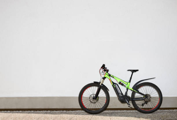 ebike in front of a white wall while sunlight at the corner stock photo