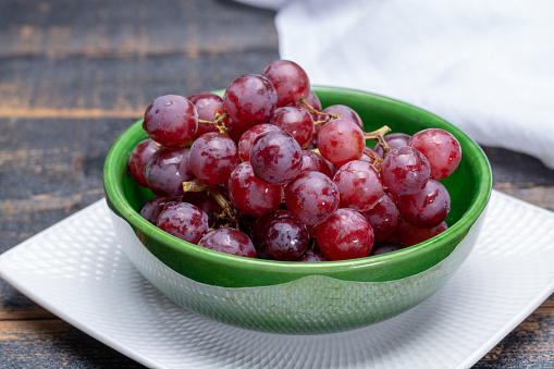Sweet ripe grapes berries in bowl ready to eat close up