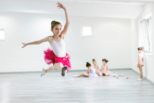 istock Child ballerina on ballet practice jumping 1014194844
