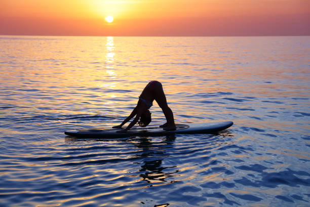 istock Sportive female doing yoga exercise on the beach 1014198896