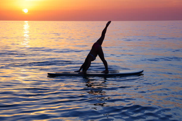 istock Sportive female doing yoga exercise on the beach 1014198904