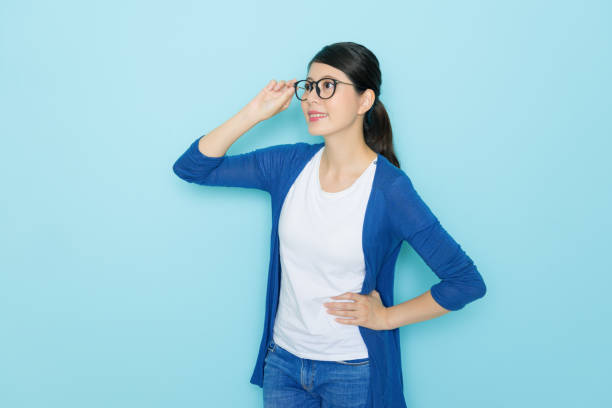 istock female student standing in blue wall background 1014206722