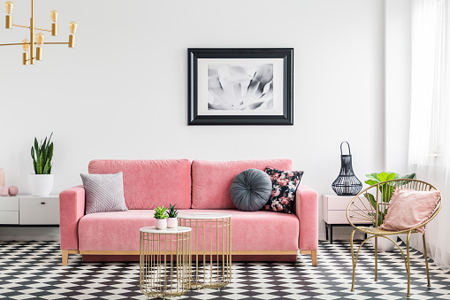 Salón glamour habitación interior con un sofá de color rosa, Sillón de oro y mesas, pintura y cuadros de azulejos. Foto real photo