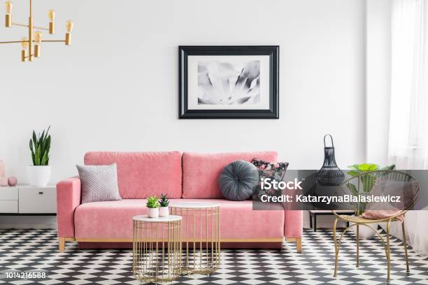グラマー生活はピンクのソファ黄金の肘掛け椅子とテーブル絵画インテリア ルームしタイルを市松します実際の写真 - 居間のストックフォトや画像を多数ご用意