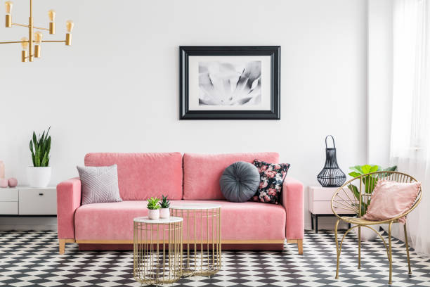 Glamour living room interior with a pink sofa, golden armchair and tables, painting and checkered tiles. Real photo Glamour living room interior with a pink sofa, golden armchair and tables, painting and checkered tiles. Real photo armchair photos stock pictures, royalty-free photos & images