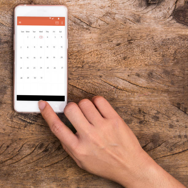 hand touching smart phone on wooden table hand touching smart phone on wooden table phone calendar stock pictures, royalty-free photos & images
