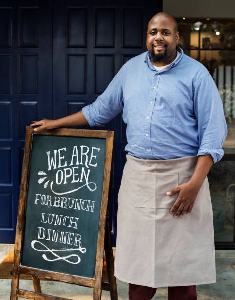 istock A cheerful business owner standing with open blackboard 1014219584