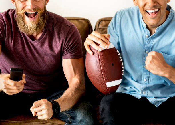 istock Friends cheering a game on television together 1014228154
