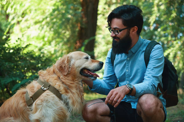 istock Handsome young man with golden retriver outdoors 1014228886