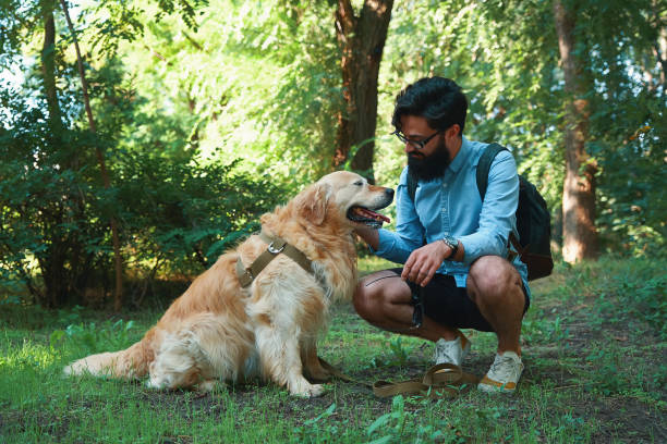 istock Handsome young man with golden retriver outdoors 1014228938