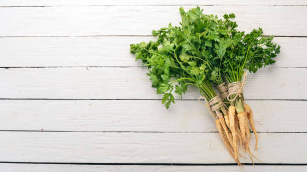 istock Fresh green parsley. Root parsley. On a wooden background. Top view. Copy space. 1014232040