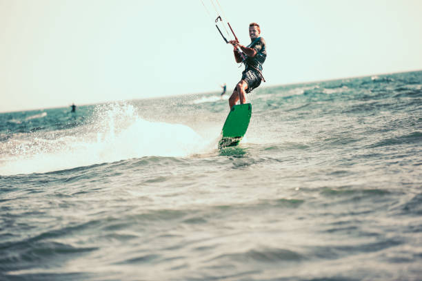 istock Athletic man riding on kite surf board 1014237964