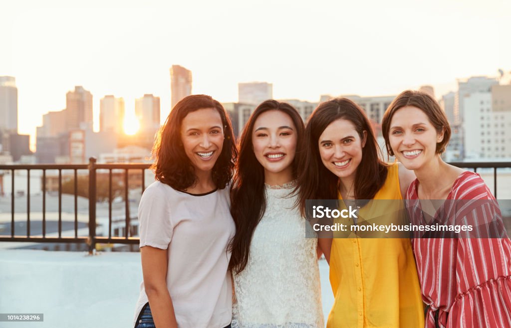 Portrait Of Female Friends Gathered On Rooftop Terrace For Party With City Skyline In Background Only Women Stock Photo