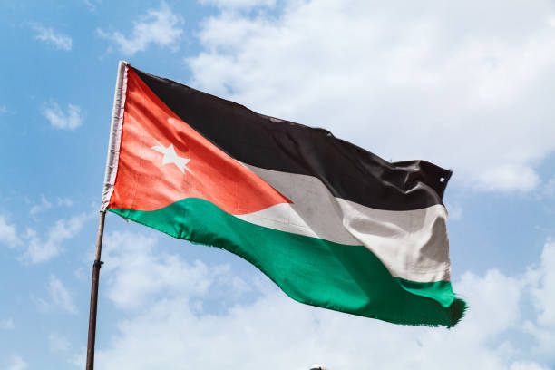 istock Flag of Jordan waving on wind over sky 1014240384