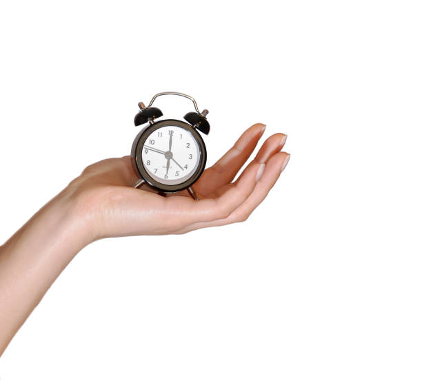 istock Woman's hand on a white background isolated with an alarm clock in retro style 1014244608