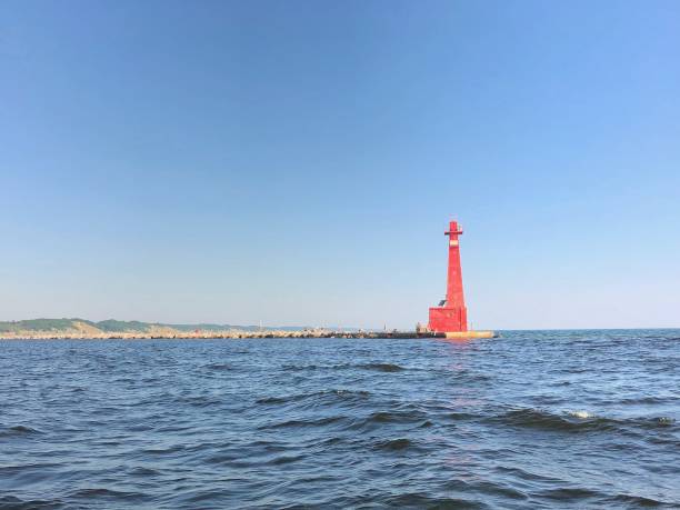 маяк на полуострове через воду - jori стоковые фото и изображения