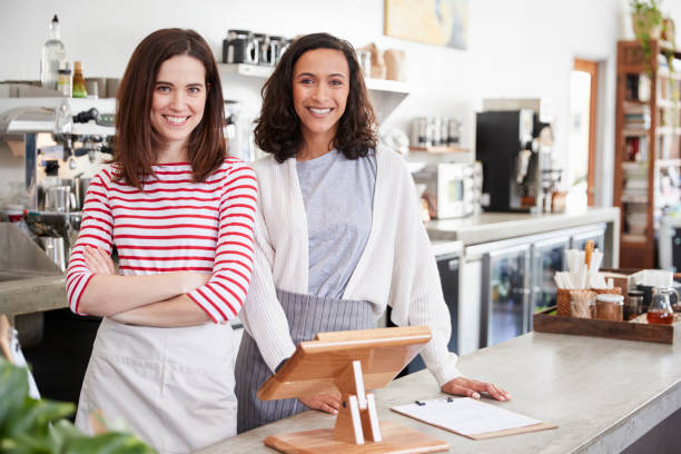 istock Two female coffee shop owners smiling behind the counter 1014251084