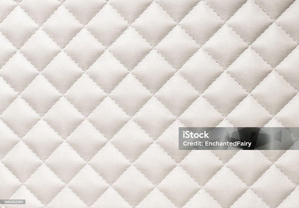 leather background pattern leather background. A closed up details of a beige leather paded upholstery pattern texture. Leather Stock Photo