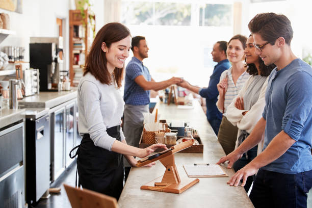 Customers queuing to order and pay at a coffee shop counter