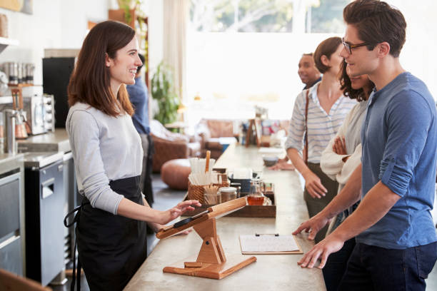 istock Customers at a coffee shop queuing to order and pay 1014253748