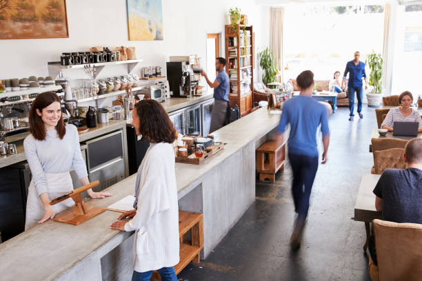 Customer at a counter of a busy coffee shop, elevated view