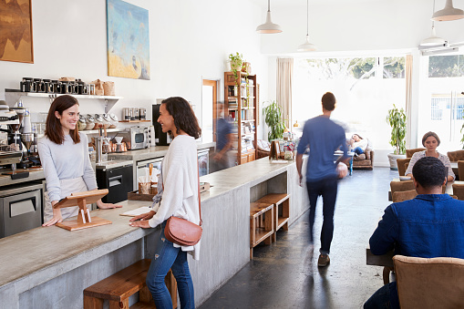 Female customer ordering at the counter in a coffee shop