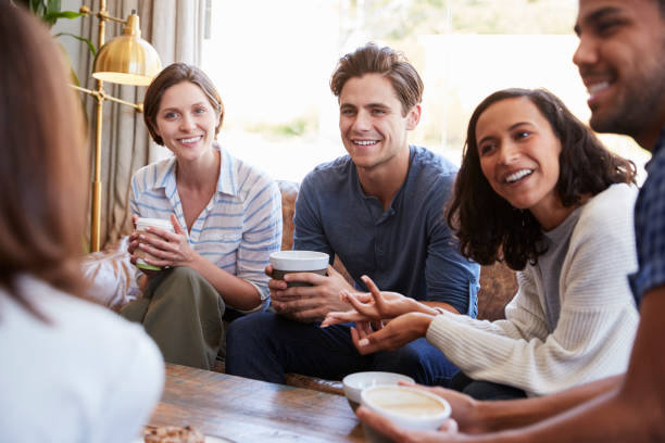 istock Friends relaxing around a table at a coffee shop, close up 1014257184