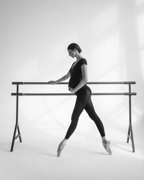 istock Young beautiful pregnant ballerina is posing in studio 1014259748