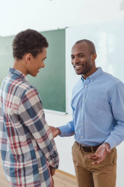 istock African american teacher talking to high school student in classroom 1014266404