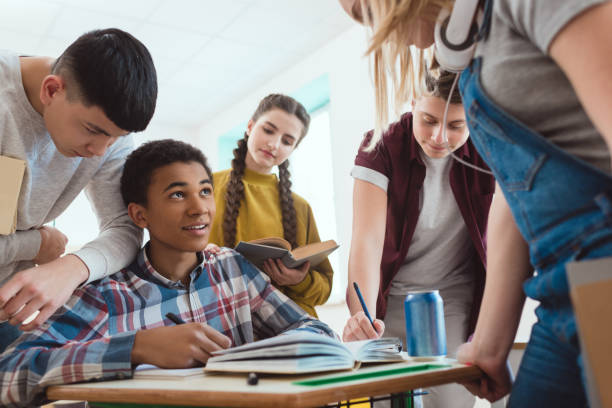 istock high school students helping their classmate with homework at school 1014266866