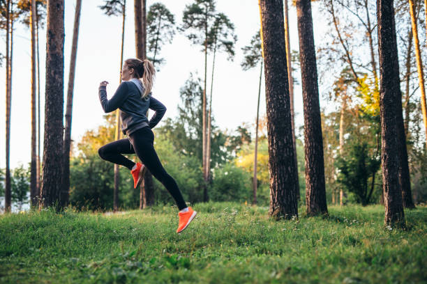 istock Young female athlete jogging in forest. Jogger doing morning physical training. 1014267384