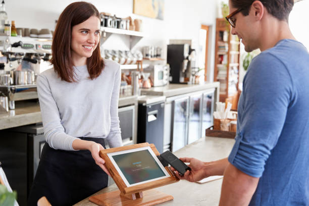 istock Male customer makes payment by smartphone at a coffee shop 1014270022